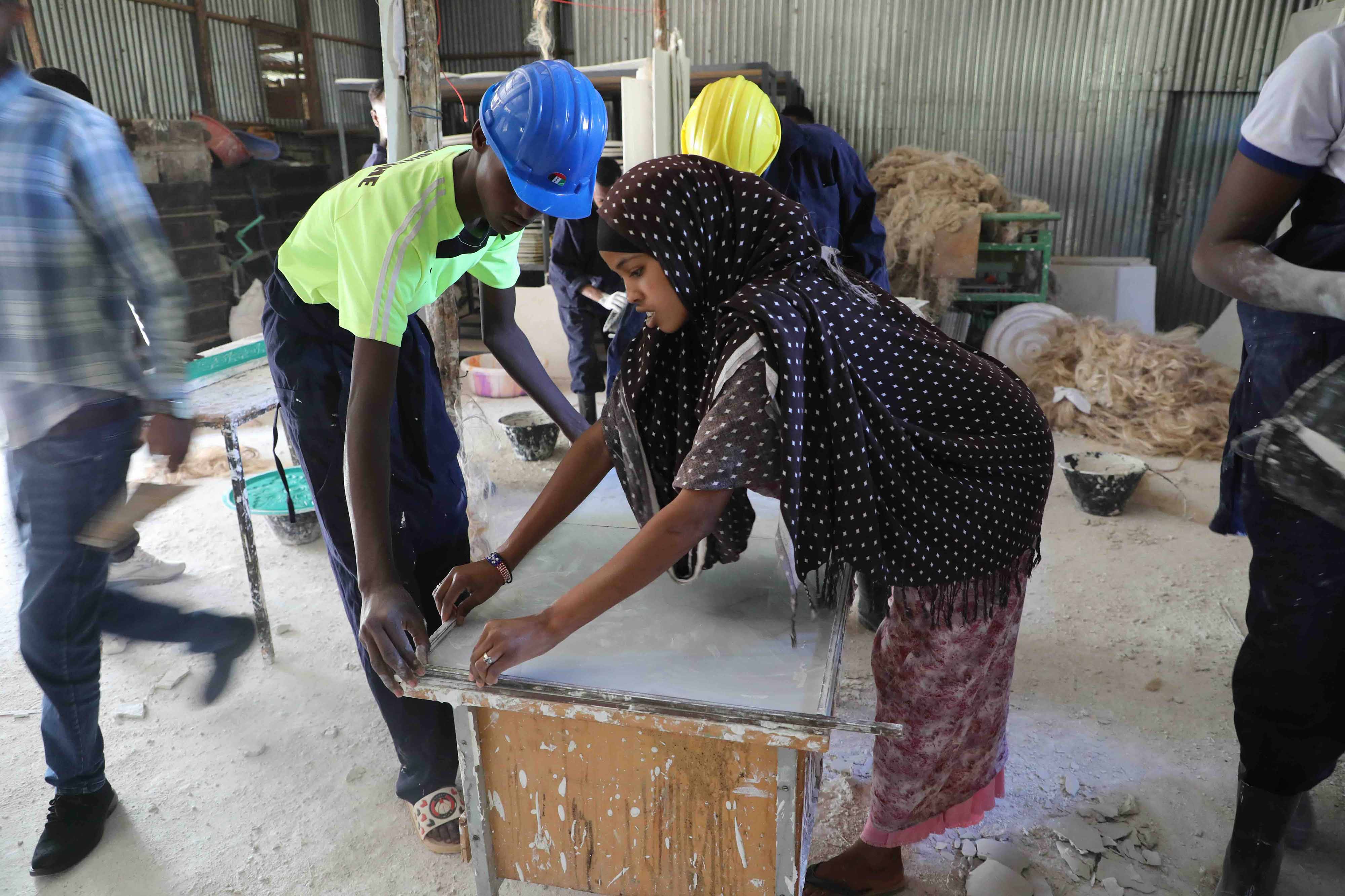 image of a a group of male and female workers in a wood cutting workshop