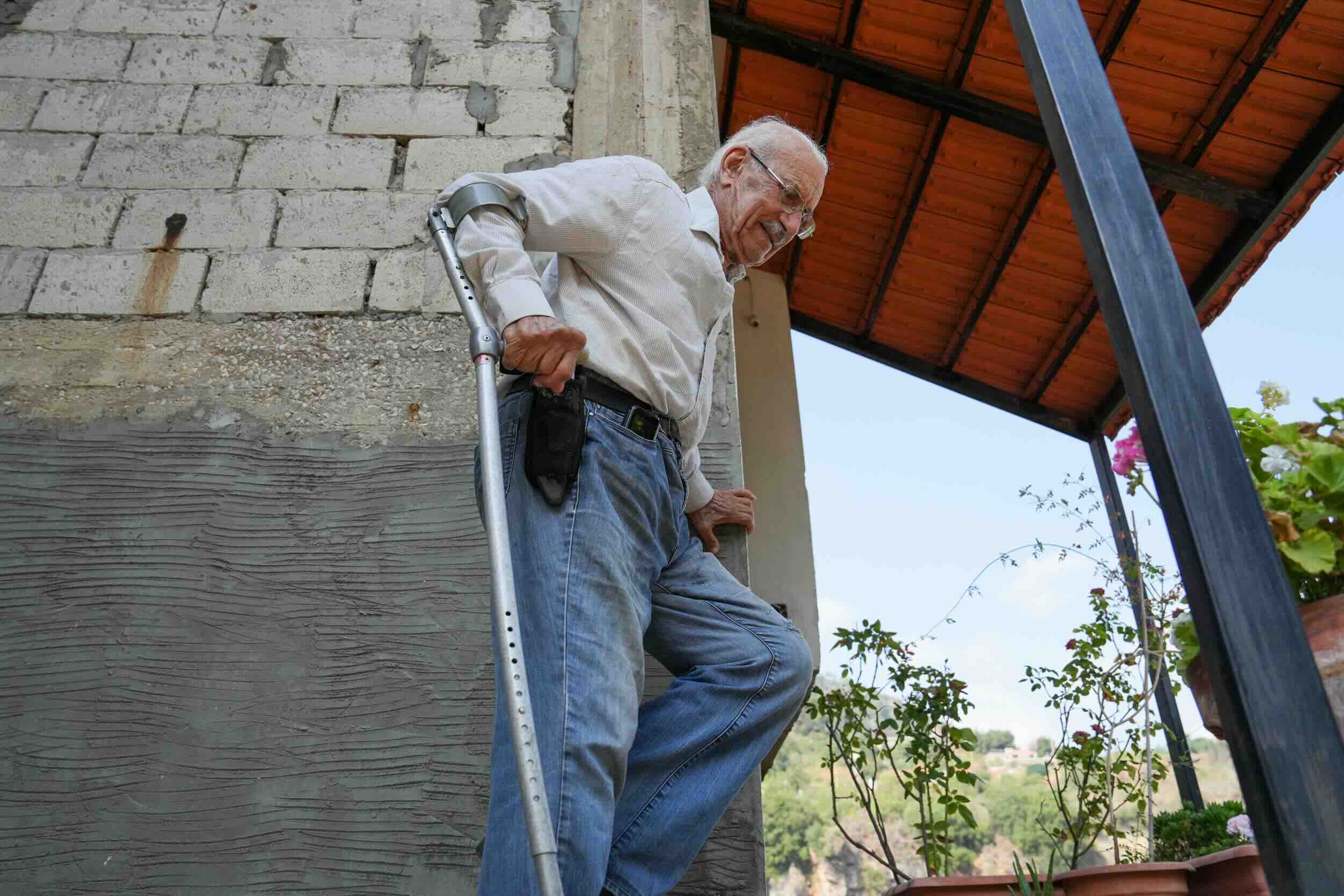 Image of an elderly person walking downstairs with a crutch