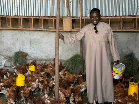 Image of a farmer feeding his chicken