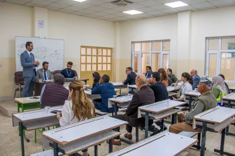 Image showing students sitting in a classroom with three teachers at the front