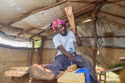 Image of a lady working in a wood workshop with tools