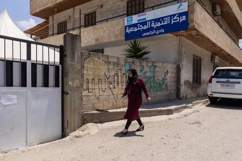 Image of a lady walking past a building on the street