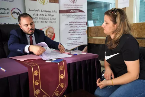 Image of a female entrepreneur talking to a banker with documents on the desk between them